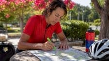 Female cyclist reviewing printed course map outdoors